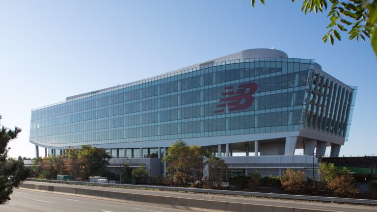 New Balance corporate headquarters in Boston featuring the brand's logo and modern footwear displays.