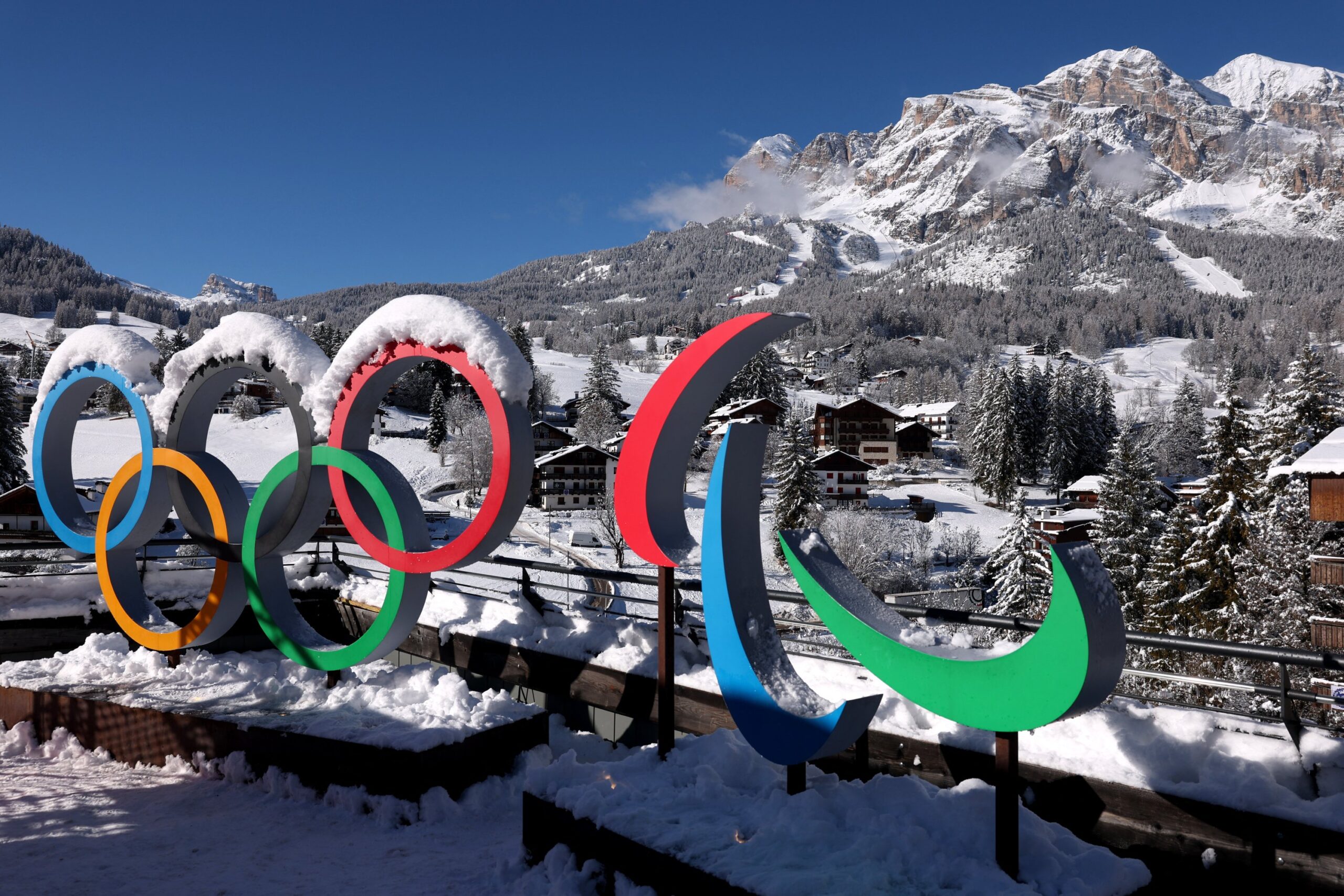 Official logo of the Milano Cortina 2026 Winter Olympics with the Italian Alps in the background.