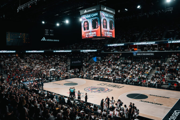 Interior view of the adidas arena during a Paris Basketball EuroLeague match featuring the giant LED screen and laser show.