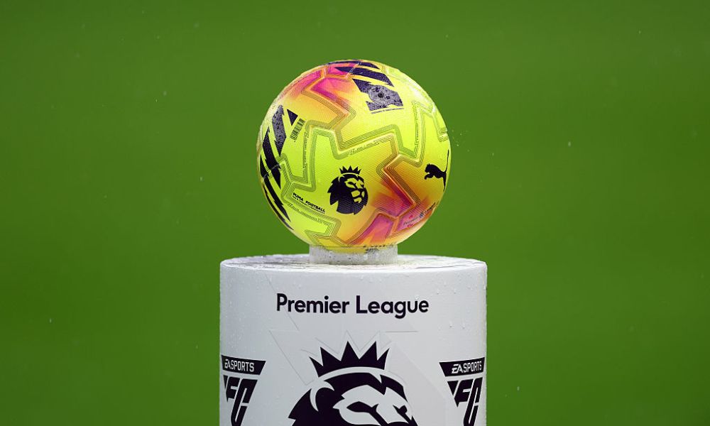 Digital pitchside advertising boards at a Premier League stadium showing various global sponsors