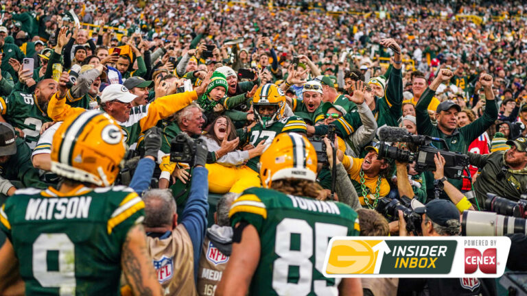 Fans wearing cheeseheads at Lambeau Field during a Green Bay Packers home game.